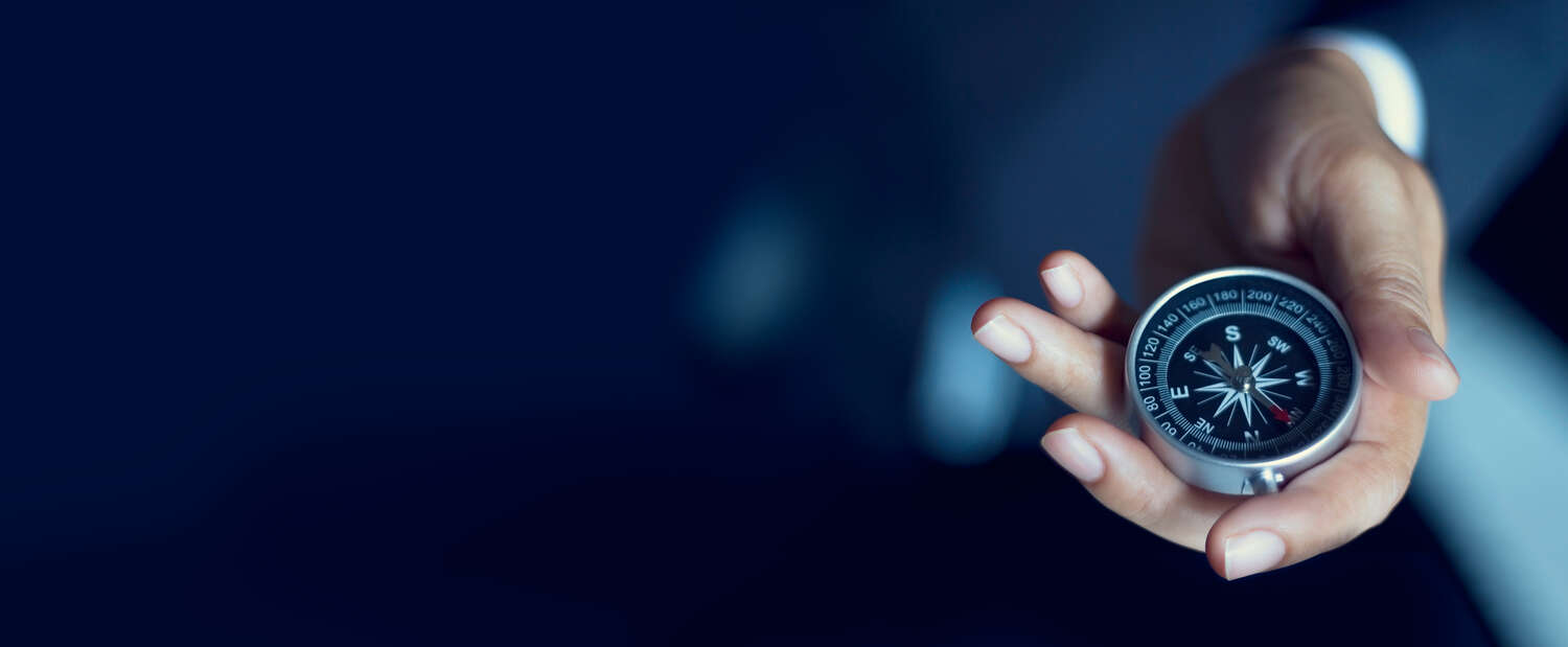 Hand holding a compass